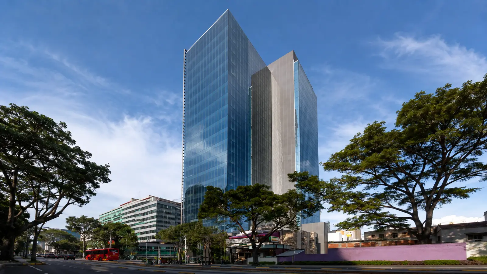 Edificio corporativo de cristal rodeado de árboles