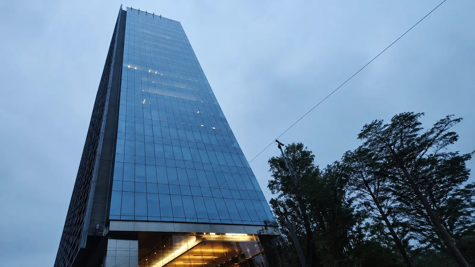 Edificio de oficinas de cristal con acceso iluminado